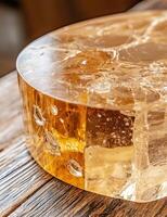 Abstract amber resin block with cracks and bubbles on a wooden surface photo