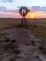 Windmill on the prairie at sunset photo