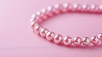 A pink bracelet with pearls on a pink background photo