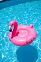 A vibrant flamingo float drifting in a pool under the sun photo