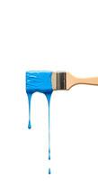 Blue paint dripping from brush isolated on white background top view High-quality top-view image of a paintbrush with blue paint dripping onto a white background ideal for artistic campaigns photo