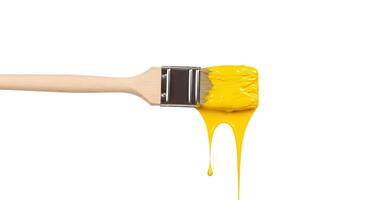 Dripping yellow paint on brush isolated on white background Detailed image of a paintbrush dripping rich yellow paint on a white background perfect for art tutorials or creative presentations photo