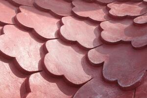 A close up of a red tile roof with a heart shape photo
