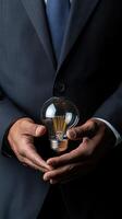 businessman holding light bulb symbolizes innovation and creativity. image captures essence of fostering new ideas and solutions in professional setting photo
