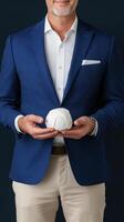 businessman in blue suit holding small white object, showcasing innovation and creativity. image conveys professionalism and focus on new ideas photo