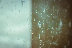 Drops on glass on rainy cloudy day evoke melancholy and sadness. View of city from the window. Selective focus. High quality photo