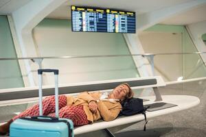 Senior tourist sleeping on airport bench while waiting for flight departure photo
