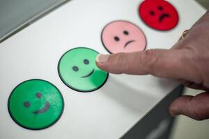 Customer pressing satisfaction level green button with a finger closeup photo