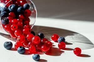 View of a lying wine glass filled with blueberries and red currants. photo