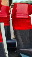 View of the red and gray passenger seats in the cabin of public transport photo