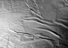 Grayscale wrinkled paper texture with folds and subtle creases, ideal for abstract and design projects. photo