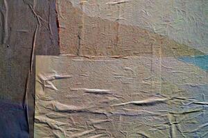 Close-up of a weathered textured surface with layered wrinkled paper, showing subtle folds, creases, and muted colors. photo