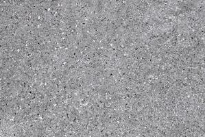 Close-up of a grey speckled stone texture, showcasing natural patterns and rough surface details. photo