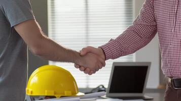two men shaking hands in an office setting photo