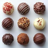 collection of nine different types of chocolates arranged in a grid-like pattern on a white background photo