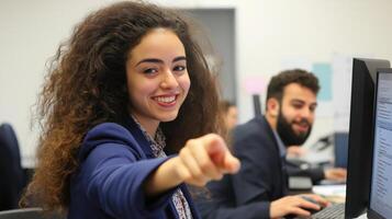 young woman with curly hair, standing in front of a computer monitor photo