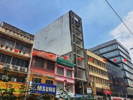 Kuala Lumpur, Malaysia on 21 February 2024. Asian City Street Scene Red Lanterns Old Buildings Modern Skyscraper photo