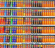 Madinah, Saudi Arabia on 28 February 2024. Colorful Potato Chip Cans Grocery Store Shelf Display photo