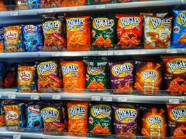 Madinah, Saudi Arabia on 28 February 2024. Colorful Bugles Snack Bags Grocery Shelf Display Vivid Packaging photo