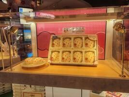 Tokyo, Japan on 08 October 2023. Strawberry Mochi Cakes Display Confectionery Shop Sweet Treats Pink Background photo