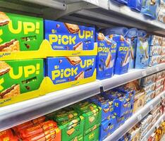 Madinah, Saudi Arabia on 28 February 2024. Pick Up Original Biscuits Grocery Shelf Display Colorful Packaging photo