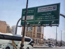 Madinah, Saudi Arabia on 2 March 2024. Green Airport Road Sign Cityscape Bus View photo