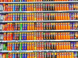 Madinah, Saudi Arabia on 28 February 2024. Colorful Snack Chip Cans Grocery Store Shelf Display photo