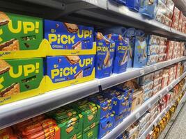 Madinah, Saudi Arabia on 28 February 2024. Pick Up Biscuits Supermarket Shelf Colorful Packaging Display photo