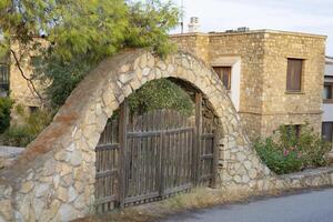 wooden gate in a stone arch, entrance to the courtyard of the house, architectural element photo