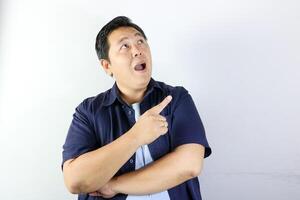 Surprised Man Pointing Upward over isolated white background photo
