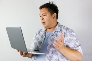 Disappointed gesture of a Man Looking at Laptop that conveying a sense of questioning or disbelief. photo