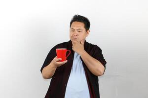 Man showing Thinking expression while holding a Red Mug photo