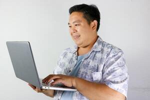 Smiling Man Working on Laptop over isolated white background photo