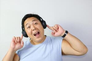 Cheerful Man enjoying music with headphones with his mouth open as if singing along photo