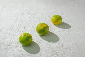 a green orange gradient citrus fruit isolated on a textured white background photo