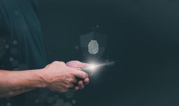 man holding smartphone with fingerprint scanner and fingerprint image on dark background photo