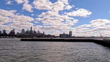 City skyline with helicopter taxi and time-lapse clouds, Scenic city skyline view with a helicopter taxi on a waterfront helipad and moving clouds video