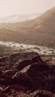 Snow covered rocky hill in middle of desert on cloudy day video