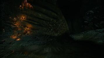 Mysterious cave with flickering candles illuminating dark rock walls video