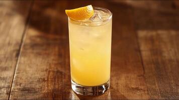 A glass of orange juice with ice cubes in it photo