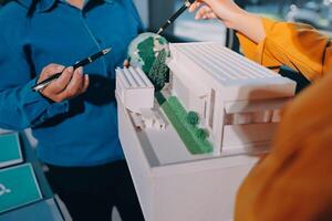 A man and woman are looking at a model of a building photo