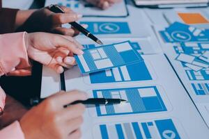 A group of people working on a project with blue and white paper photo