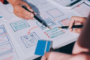 A person is working on a design document with a pen photo