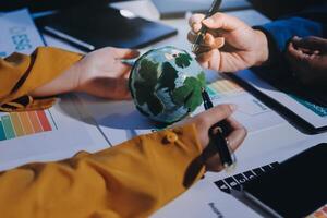 People working on a project with a globe on a table photo
