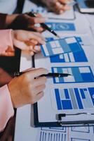 A group of people working on a project with blue and white papers photo