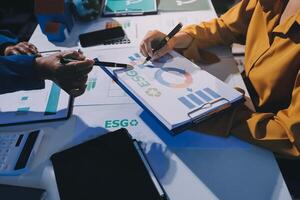 Business people working on a project with graphs and papers photo