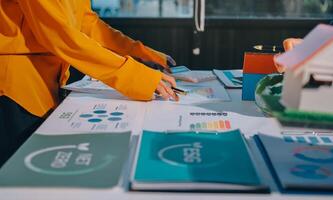 Business people working on a table with graphs and papers photo