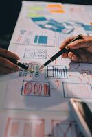 A person is working on a design document with a pen photo