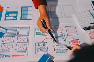 A person is working on a design with a pen and calculator photo