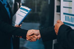 Two business people shaking hands in front of a building photo